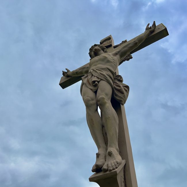 Jesus on the cross against cloudy sky