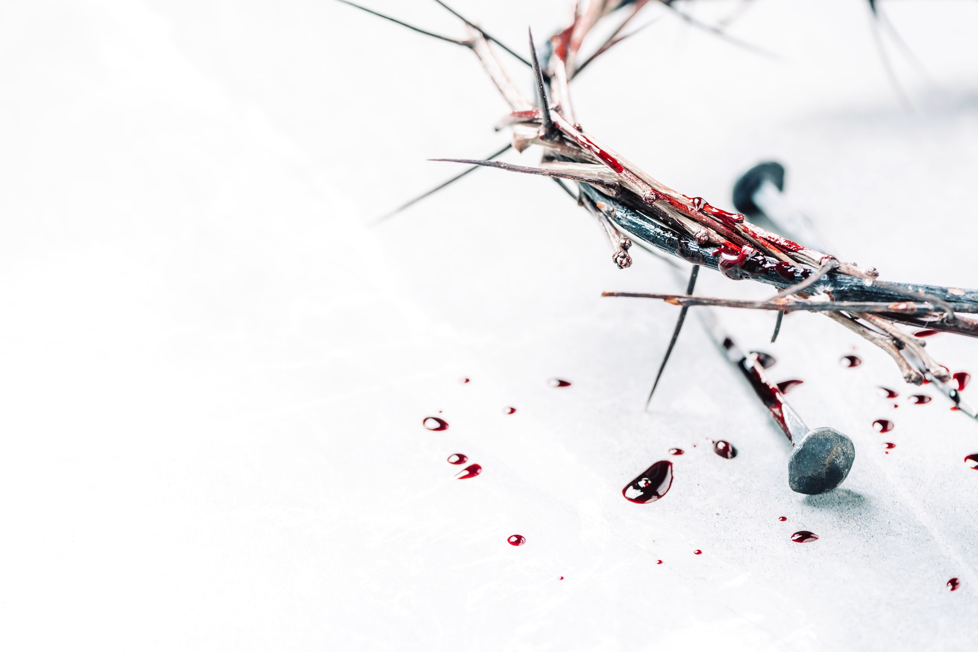 Crown of thorns with blood dripping, nails on stone. Christian concept of Jesus Christ suffering